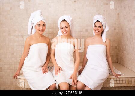 Drei Freundinnen sitzen in einem Hammam. Orientalische Bäder, Frau entspannen in einem Hammam. Wellness-Wochenende für Frauen Stockfoto