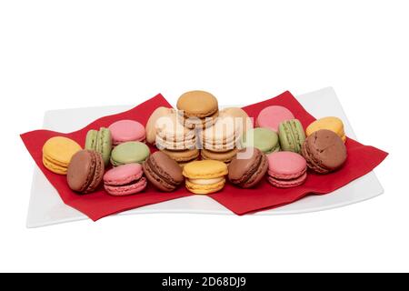 Nahaufnahme von bunten französischen Makronen sind wunderschön auf roten Servietten auf einem weißen Teller auf weißem Hintergrund angeordnet. Gebäck, Desserts und Swe Stockfoto