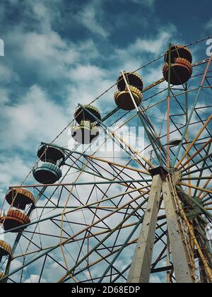 Alte Riesenrad über Himmel Hintergrund in einem verlassenen Vergnügungspark. Dunkle Szene, Geist und leeres Karussell ohne Leute für Unterhaltung. Stockfoto