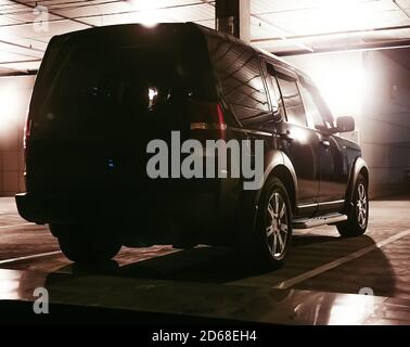 Auto in einem überdachten mehrstöckigen Parkplatz in der Nacht Stockfoto