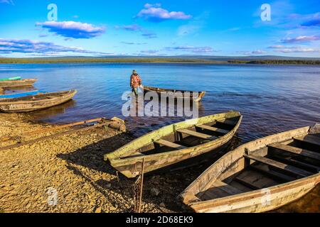 Fischer, die im Wasser mit einem Boot entlang der Ufer des Sees Stockfoto