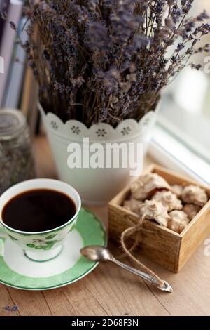 Bücher, Kaffee und ein Bouquet von getrocknetem Lavendel. Stillleben auf dem Tisch. Frühstück, Aussicht von oben. Eine Tasse belebenden Getränks. Startseite gemütlich Hintergrund. Stockfoto