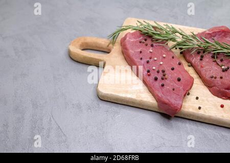 Zwei rohe Rib Eye Steak auf Holzschneidebrett. Rindersteak in Scheiben Stockfoto