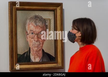 London, Großbritannien. 15. Oktober 2020. Ein Mitarbeiter blickt auf „Self-Portrait“, 1959, von Stanley Spencer. Die Arbeit ist Teil der neuen Ausstellungen in den drei Sammlungsrouten der Tate Britain: Rothko und Turner (eine neue Route, die 50 Jahre feiert, seit Mark Rothko Tate seine ikonischen Seagram Murals zum ersten Mal gab, um Gemälde zu verbinden, die er so bewunderte von JMW Turner), British Art 1540-1920 und British Art 1930-Now. Besucher können online kostenlos buchen, um das Museum zu besuchen. Kredit: Stephen Chung / Alamy Live Nachrichten Stockfoto