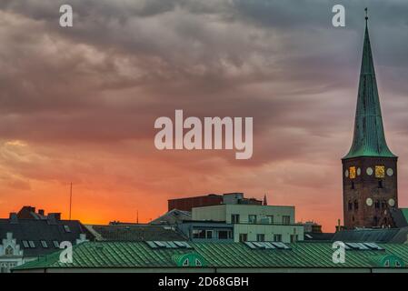 Skyline der Stadt bei Sonnenuntergang aus der beliebten DOKK1-Bibliothek aufgenommen Mit dem Domkirke (Kathedrale) Glockenturm, der aus dem Downtown Häuser "Dächer Stockfoto