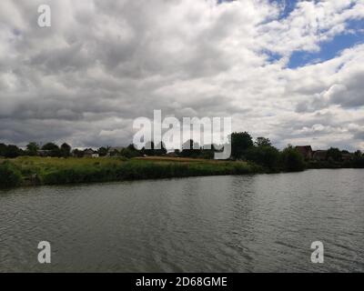 Ein großes Flussbett mit Gras und Bäumen im Sommer Stockfoto