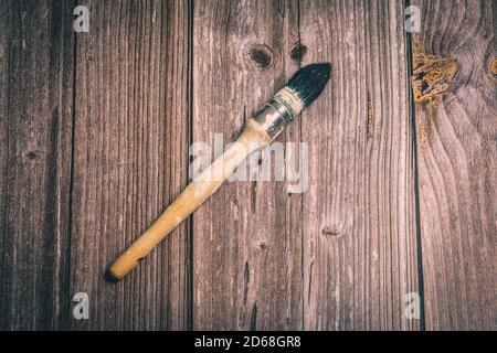 Ein alter Holzpinsel auf einem rustikalen Holztisch gelegt Stockfoto