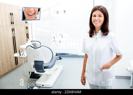 Portrait Zahnärztin trägt eine Schutzbrille und steht in ihrer Klinik. Stockfoto