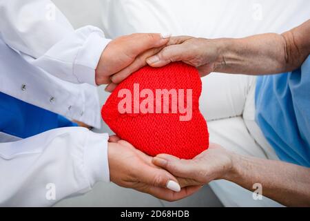 Medizinische Betreuung von Parkinson-Kranken. Hände eines Arztes stützen die Hände einer älteren Frau. Medizinische Versorgung für die Gesundheit alter Menschen Stockfoto