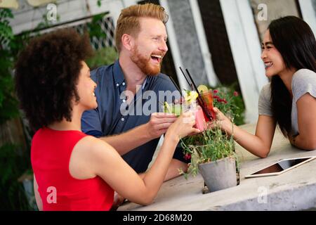 Gruppe von verschiedenen Freunden reden und Spaß im Café im Freien Stockfoto