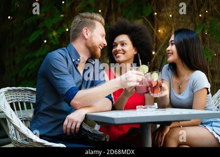 Gruppe von verschiedenen Freunden reden und Spaß im Café im Freien Stockfoto