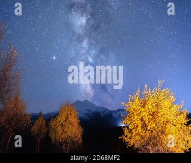 Milchstraße über Mount Elbrus und orange Herbstbäume, Nacht Herbstlandschaft Stockfoto