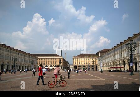 Panoramablick auf die piazza san carlo, die von Einheimischen und Touristen besucht wird. Ein Junge benutzt ein kommunales Leihfahrrad Stockfoto