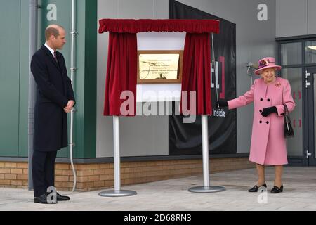 Der Herzog von Cambridge sieht zu, wie Königin Elizabeth II. Eine Plakette enthüllt, um das neue Energetics Analysis Center am Defense Science and Technology Laboratory (DSTL) in Porton Down, Wiltshire, offiziell zu eröffnen. Stockfoto