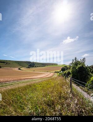 The South Downs und Long man of Wilmington, Sussex, England. Ein ländlicher Fußweg, der zu einem englischen Sommerblick auf die Landschaft führt, mit einer charakteristischen Hügelfigur. Stockfoto