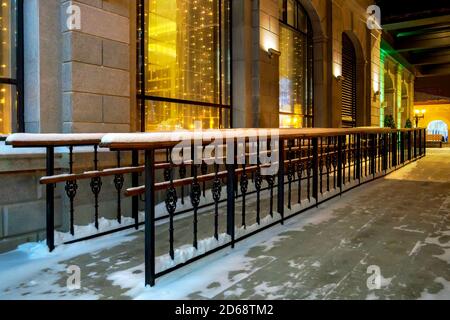 Metallrampe mit Holzgeländern für Rollstühle und Kinderwagen Gebäude im Winter Abend Stockfoto