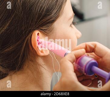 Verfahren der Herstellung von Ohrstöpseln aus einem Eindruck eines individuellen s Kinderohr. Nahaufnahme des Ohrs. Persönlich geformte Ohrstöpsel. Teil des Sets Stockfoto