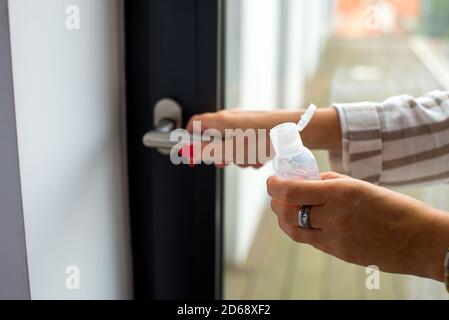 Frauenhand mit sauberem Gel, um die Hände zu waschen, um Keime zu töten, bevor sie ein- und ausgehen. Konzept der Sauberkeit und Hygiene. Verhindern von covid-19. Frau bewerben Stockfoto