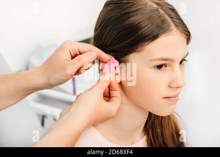 Verfahren der Herstellung von Ohrstöpseln aus einem Eindruck eines individuellen s Kinderohr. Nahaufnahme des Ohrs. Persönlich geformte Ohrstöpsel. Teil des Sets Stockfoto