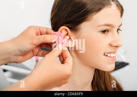 Verfahren der Herstellung von Ohrstöpseln aus einem Eindruck eines individuellen s Kinderohr. Nahaufnahme des Ohrs. Persönlich geformte Ohrstöpsel. Teil des Sets Stockfoto