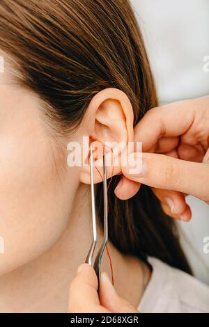 Prozess der Herstellung von Ohrstöpsel aus einem Eindruck eines einzelnen s Frau Ohr. Nahaufnahme des Ohrs. Persönlich geformte Ohrstöpsel. Teil des Sets Stockfoto