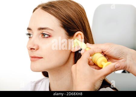 Persönlich geformte Ohrstöpsel. Prozess der Herstellung von Ohrstöpsel aus einem Eindruck eines einzelnen s Frau Ohr. Audiologie. Teil des Sets Stockfoto