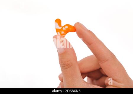 Isoliert auf weißem Ohrstöpsel in der Hand. Persönlich geformte Ohrstöpsel Nahaufnahme Stockfoto