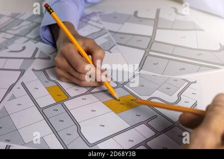 Menschen diskutieren über Territorialbaugrundstücke auf Katasterkarte Stockfoto