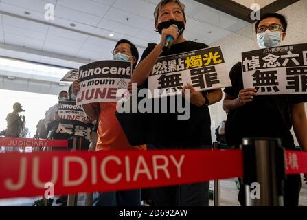 Der Politiker und Aktivist Lee Cheuk-yan (C) hält zusammen mit anderen Aktivisten Plakate mit der Botschaft "Unschuldig zu trauern", während sie vor ihrem Prozess durch das West Kowloon Gericht gehen.der Medien-Tycoon Jimmy Lai und andere pro-demokratische Aktivisten, darunter Joshua Wong, erscheinen vor Gericht wegen der Anschuldigungen der Teilnahme und Organisation an Illegale Anti-Regierung Tiananmen Platz Vigil Versammlung im Juni 2019. Stockfoto
