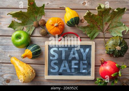 Thanksgiving COVID 19 Tage. SICHERE Botschaft und Danksagung Flatlay auf Holzhintergrund zu BLEIBEN. Coronavirus-Schutz Stockfoto