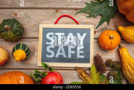 Thanksgiving COVID 19 Tage. SICHERE Botschaft und Danksagung Flatlay auf Holzhintergrund zu BLEIBEN. Coronavirus-Schutz Stockfoto