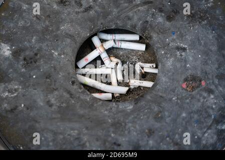 Zigarettenkippen im schwarzen Aschenbecher. Stockfoto