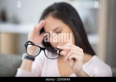 Müde Geschäftsfrau hält Brillen leiden Augenschmerzen Stockfoto