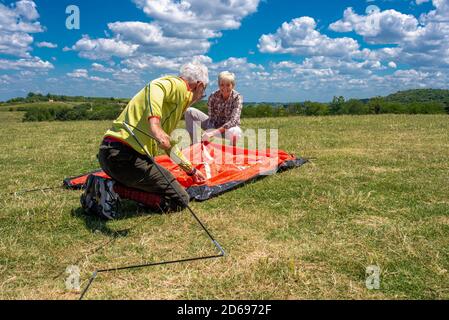 Seniorenpaar bereitet sich auf die Erholung vor, legt ein Zelt auf Stockfoto