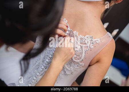 Nahaufnahme einer Frau, die ein Hochzeitskleid fixiert Stockfoto