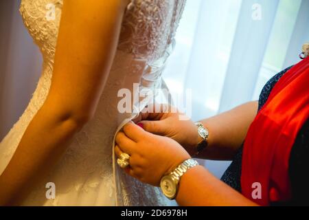 Nahaufnahme einer Frau, die ein Hochzeitskleid fixiert Stockfoto