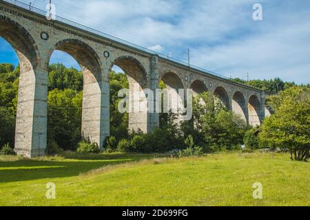 Zugviadukt in Altenbeken, Nordrhein-Westfalen, Deutschland. Alte Steinbahn umgeben von grünen Park Stockfoto