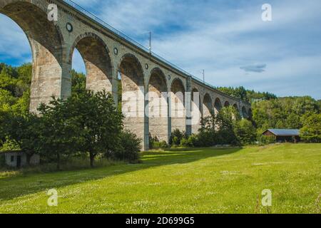 Zugviadukt in Altenbeken, Nordrhein-Westfalen, Deutschland. Alte Steinbahn umgeben von grünen Park Stockfoto