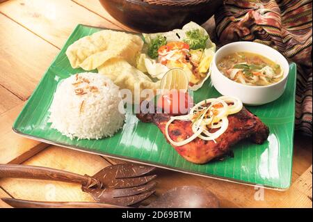 Traditionelles indisches Gericht Tandoori Chicken mit Reis, Suppe und Gemüse Stockfoto