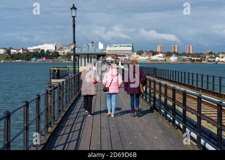 Southend Pier, Southend on Sea, Essex, Großbritannien. Oktober 2020. Wechselhaftes, aber häufig sonniges, wenn auch kühles Wetter zog die Leute zum Southend Pier in der Themse Mündung an. Southend bleibt auf Stufe 1 COVID-19. Drei ältere Frauen gehen zurück in Richtung Stadt Stockfoto