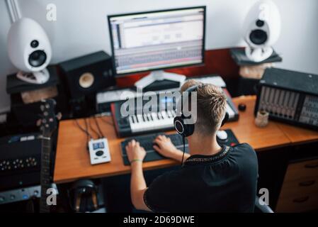Tontechniker in Kopfhörern arbeiten und Musik in Innenräumen mischen Das Studio Stockfoto
