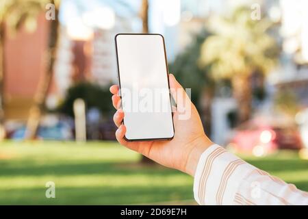 Handy-Bildschirm mockup von einer jungen Frau auf dem gehalten City Street Stockfoto