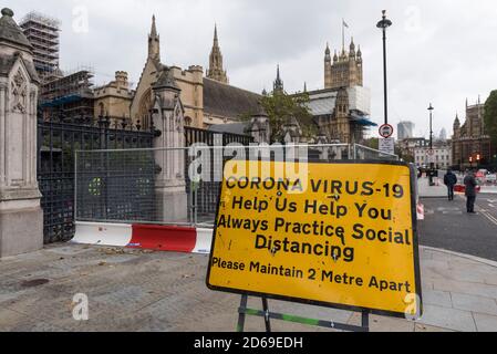 London, Großbritannien. 15. Oktober 2020. Ein Coronavirus-Warnschild vor den Houses of Parliament in Westminster. Derzeit England Alarmstufe : Tier 1, gilt, aber um zu versuchen, die Coronavirus-Pandemie weiter zu kontrollieren, hat die britische Regierung heute angekündigt, dass ab Samstag die Hauptstadt, sowie andere Regionen in Großbritannien, wird auf die strengere England Warnstufe bewegen :Tier 2, hoch. Kredit: Stephen Chung/Alamy Live Nachrichten Stockfoto