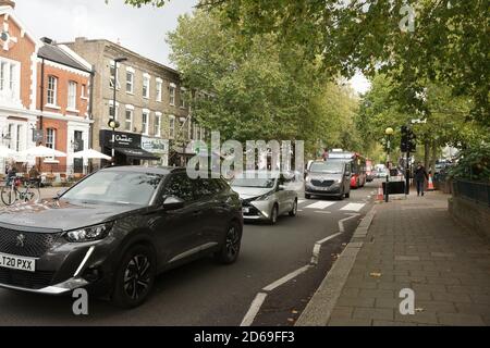 London, Großbritannien. Oktober 2020. Die Fortsetzung der Radspurarbeiten auf der Chiswick High Road führt zu einer drastischen Einenmung des Verkehrsflusses. Busse haben keine eigenen Fahrspuren mehr und holen Passagiere ab, die den Radweg überqueren müssen, um an Bord zu gehen. Kredit: Peter Hogan/Alamy Live Nachrichten Stockfoto