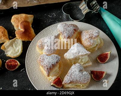 Herzförmige Cremepuffs mit Cremefüllung Stockfoto