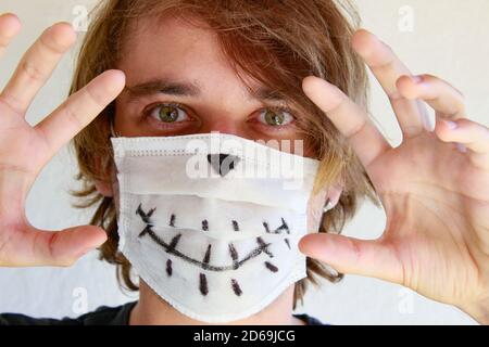 Junger Mann feiert Halloween mit medizinischer Gesichtsmaske wegen Covid-19 Pandemie Stockfoto