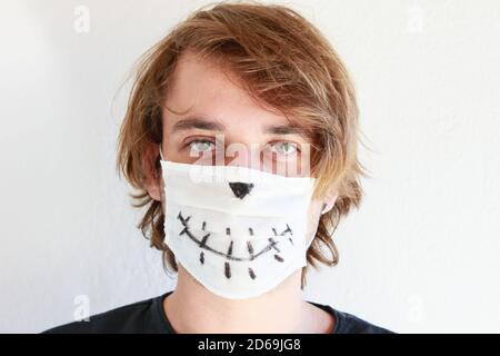 Junger Mann feiert Halloween mit medizinischer Gesichtsmaske wegen Covid-19 Pandemie Stockfoto