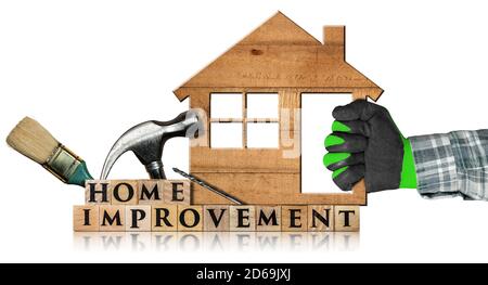 Hand mit Arbeitshandschuh mit einem Holzmodellhaus mit Text Home Improvement aus Holzblöcken, Pinsel, Hammer und Bohrer. Isoliert. Stockfoto