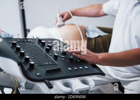 Männliche Arzt tut Ultraschall für eine schwangere Frau in der Krankenhaus Stockfoto