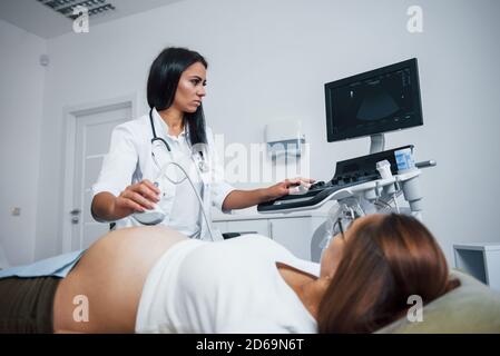 Ärztin macht Ultraschall für eine schwangere Frau in der Krankenhaus Stockfoto